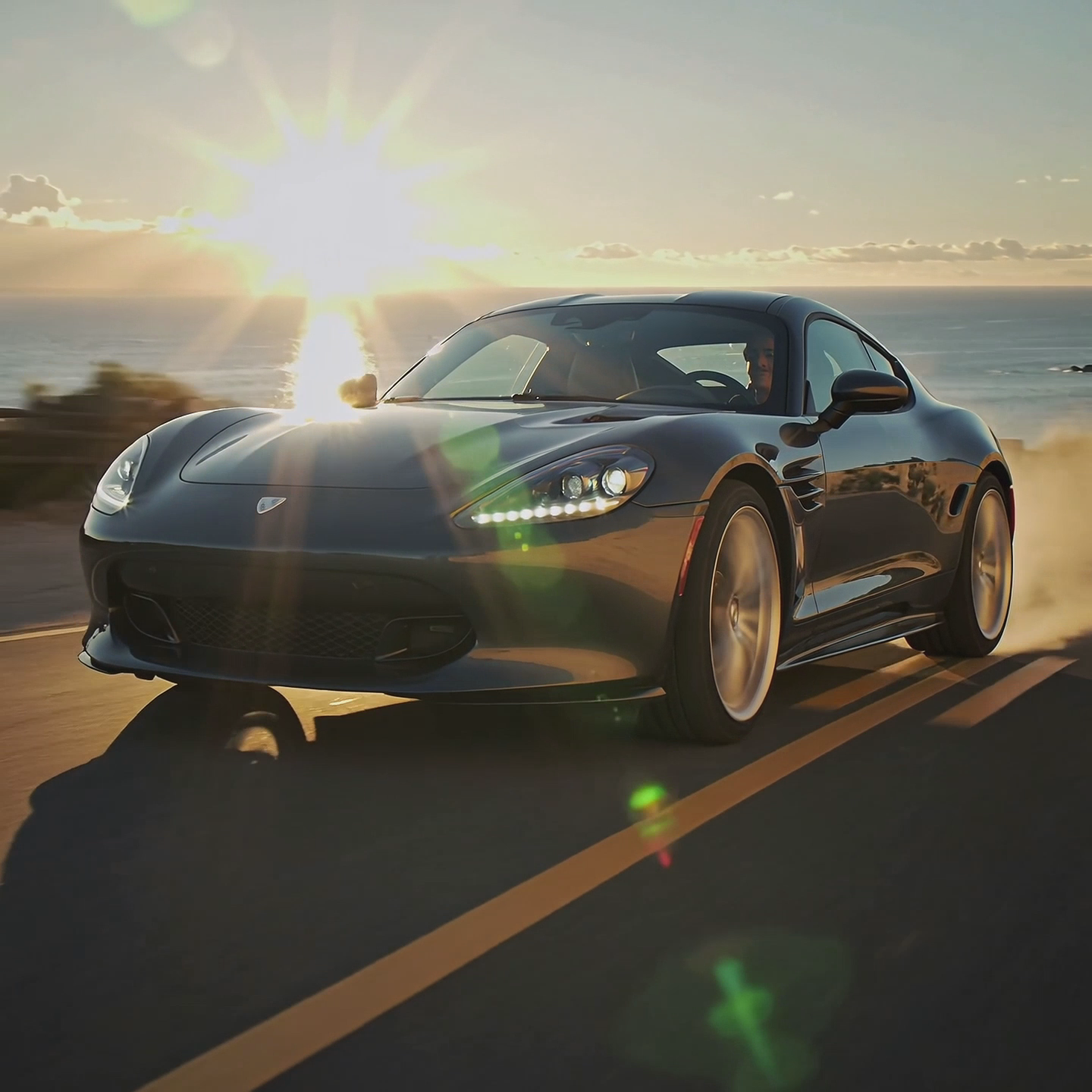 A modern car driving on Pacific Coast Highway 1. The camera follows the car and zooms out to reveal the horizon
