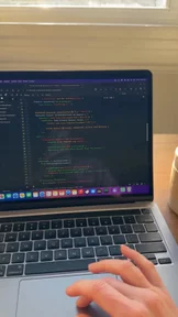 Hand peeling code from a laptop screen, created with VideoGen
